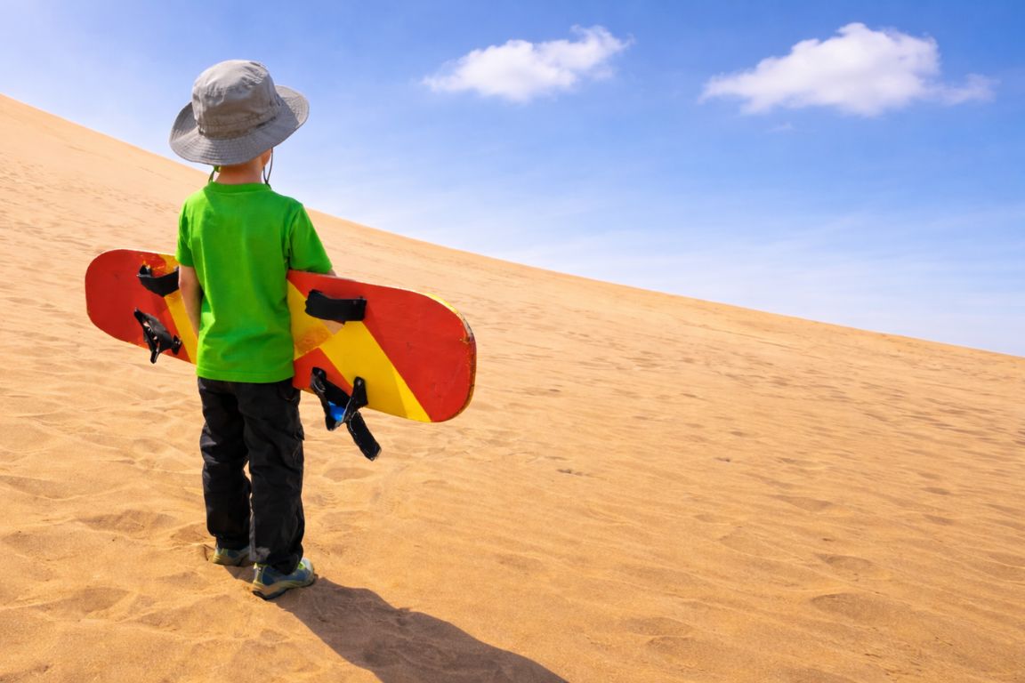 Kid preparing to sandboard in Huacachina Peru on Huacachina Tours desert excursion